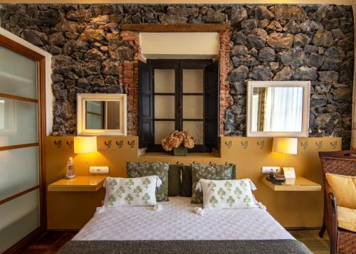 a bedroom with a bed and a stone wall at Mar Del Sueve in Colunga