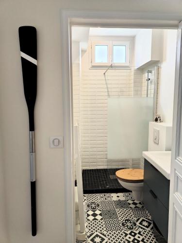 La salle de bains est pourvue d'une douche et d'un sol noir et blanc. dans l'établissement Pied à terre en bord de mer, à Pornic