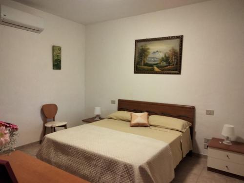 ein Schlafzimmer mit einem Bett und einem Bild an der Wand in der Unterkunft Casale di Valle Fredda in Itri