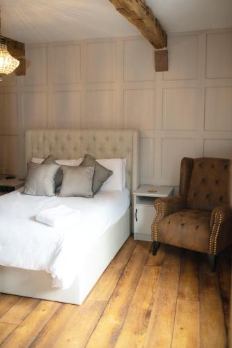 una camera con un letto bianco e una sedia di Bulls Head Inn Rooms ad Alton