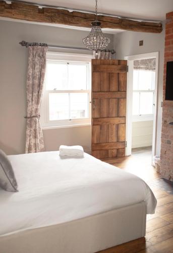 Un dormitorio con una gran cama blanca y una ventana en Bulls Head Inn Rooms en Alton