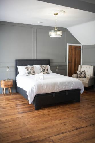 1 dormitorio con 1 cama grande y 1 silla en Bulls Head Inn Rooms en Alton