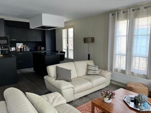 un salon avec un canapé blanc et une table dans l'établissement Appt standing Coeur de ville Chateau et Marché, à Versailles