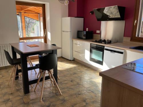 une cuisine avec une table et une cuisinière four supérieur dans l'établissement Maison dans un village viticole, à Boyeux-Saint-Jérôme