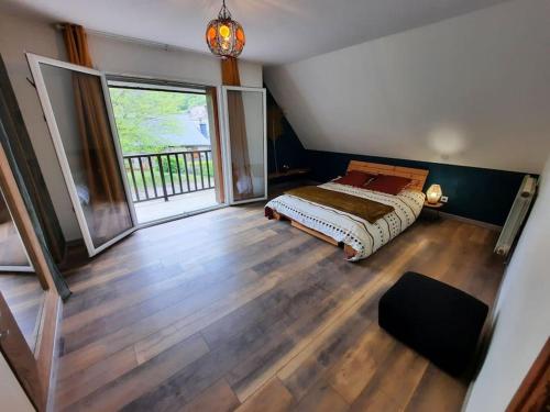 une chambre avec un lit et une grande fenêtre dans l'établissement Maison avec jardin près de Luchon, à Cazaux-Layrisse
