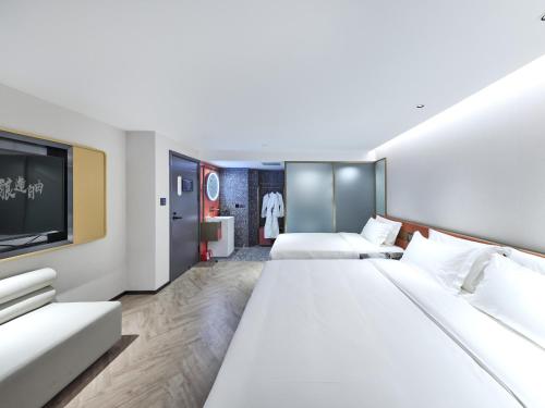 a hotel room with two beds and a flat screen tv at M Hotel - Beijing Tiananmen Square Qianmen Subway Station in Beijing