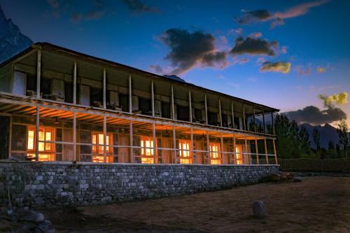a large building with lights on in the night at Guzel Hotel in Shigar