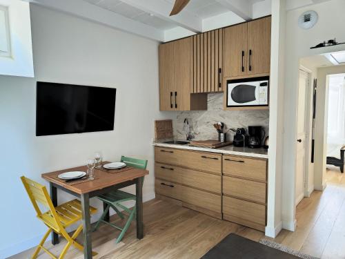 une cuisine avec une petite table et un micro-ondes dans l'établissement Pied à terre en bord de mer, à Pornic