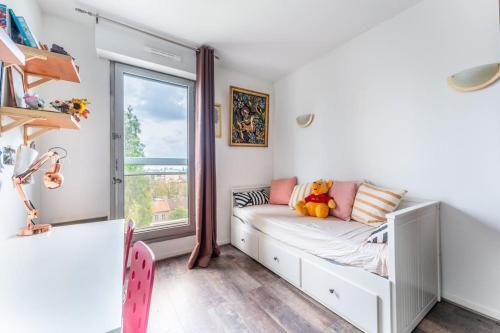 um quarto para crianças com uma cama e uma janela em Appartement avec terrasse a 5 min de Paris em Les Lilas