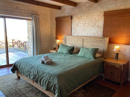 1 dormitorio con 1 cama con edredón verde en Kite View 2 Holiday Home, en Witsand