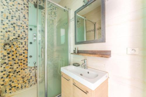 uma casa de banho com um lavatório e um chuveiro em Appartement avec terrasse a 5 min de Paris em Les Lilas