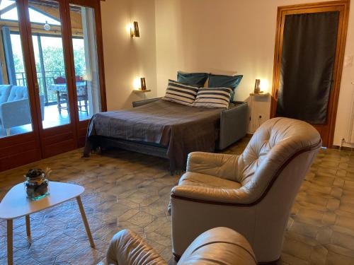ein Schlafzimmer mit einem Bett, einem Sofa und einem Tisch in der Unterkunft Maison dans un village viticole in Boyeux-Saint-Jérôme