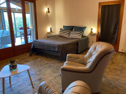 una camera da letto con un letto, un divano e un tavolo di Maison dans un village viticole a Boyeux-Saint-Jérôme