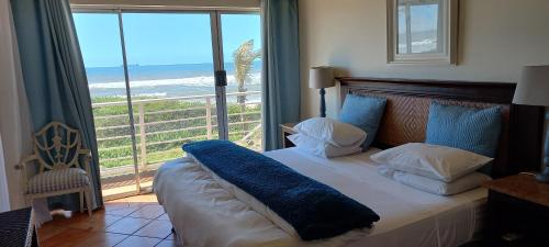 a bedroom with a bed with a view of the ocean at Bentley on the Beach in Umhlanga