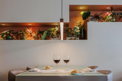 two glasses of wine on a table with plants at Hotel Vilamarí in Barcelona