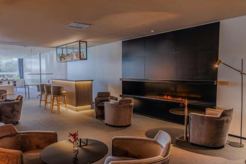 a lobby with a fireplace and chairs and tables at Hotel Vilamarí in Barcelona