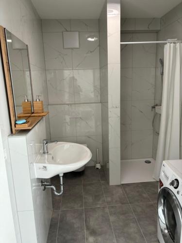 a white bathroom with a sink and a shower at Kikis FEWO in Friesenheim