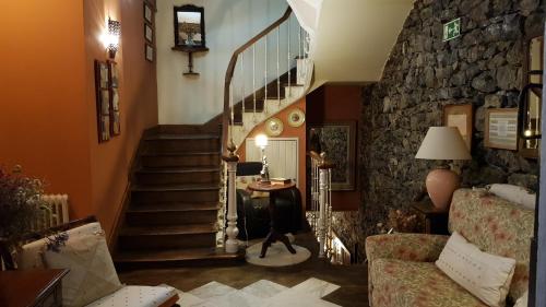 a living room with a staircase with a stone wall at Mar Del Sueve in Colunga