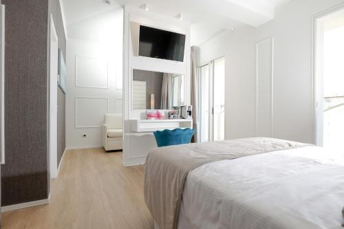 a white bedroom with a bed and a desk at Hotel Alexander in Milano Marittima