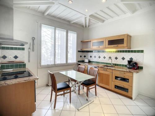 une cuisine avec une table et des chaises dans l'établissement Riad privé en plein centre de Vichy, à Vichy