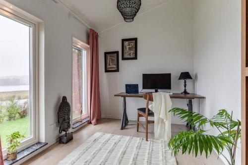 Zimmer mit einem Schreibtisch, einem Computer und einem Fenster in der Unterkunft Captivating 3-Bed Villa in Halanda with Lake View in Sandåker