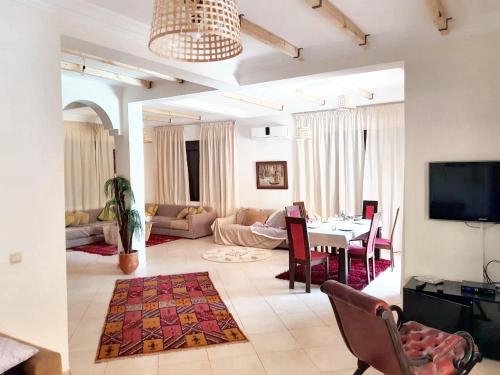 ein Wohnzimmer mit einem Tisch und einem Esszimmer in der Unterkunft 3 bedrooms villa with private pool enclosed garden and wifi at Marrakech in Aït Ali