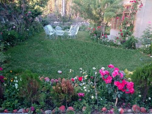 a garden with chairs and flowers in a yard at Ilyasin Guest House in Skardu