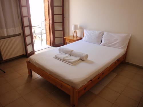 a bedroom with a bed with towels on it at Vazakas Rooms in Mytilene