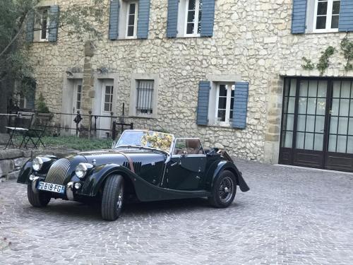 un viejo coche negro estacionado frente a un edificio en Domaine du Moulin de Villefranche en Pernes-les-Fontaines