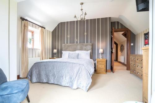 a bedroom with a large bed and a blue chair at Glenvela guest house in Castlerea