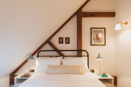 a bedroom with a large bed with white sheets at Buckingham Mews_Flint Cottage 2 in Broadstairs