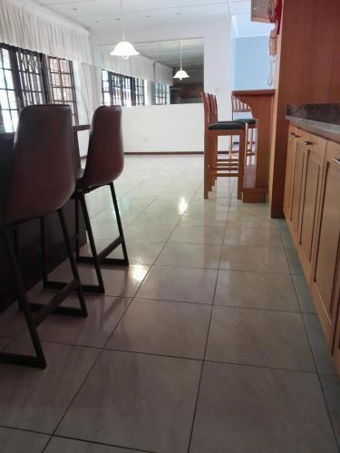eine Küche mit Fliesenboden, Stühlen und einem Tisch in der Unterkunft Lala vuka in Sunkelsdrif