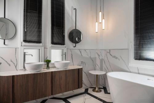 a bathroom with two sinks and a bath tub at Hotel Maestrale in Riccione