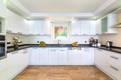 a white kitchen with white cabinets and a window at Sofia Ada in Fethiye