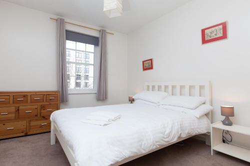 a bedroom with a white bed and a window at Attractive Edinburgh Leith Apartment in Edinburgh