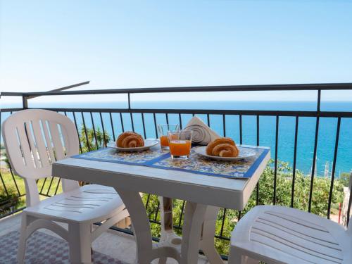 a table with a plate of pastries on a balcony at Kalimera Apartment in Santo Stefano di Camastra