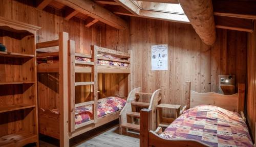 a bedroom with two bunk beds in a cabin at Chalet Les Liouès in Sollières-Sardières