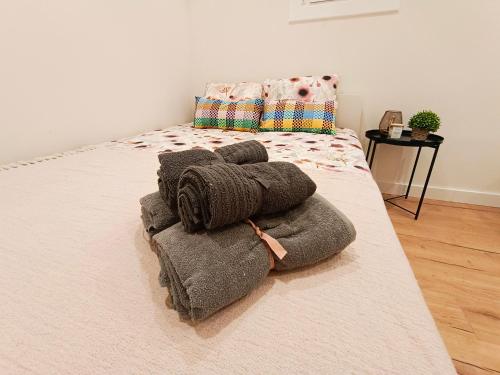 a bed with a pile of towels on it at El born private rooms in Barcelona