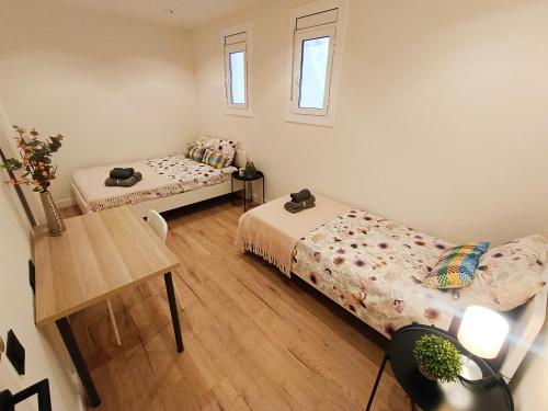 um quarto com duas camas e uma mesa em El born private rooms em Barcelona