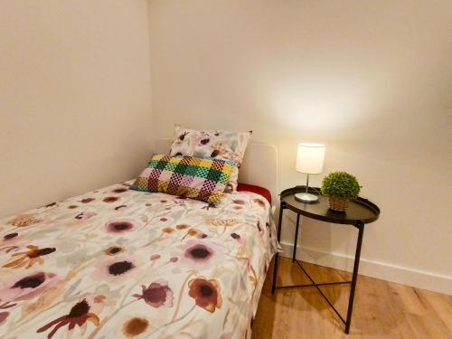 una camera con letto e tavolo con lampada di El born private rooms a Barcellona