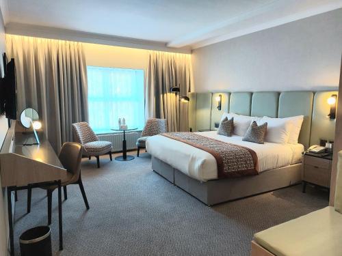 高威的住宿－門羅公園酒店，配有一张床和一张书桌的酒店客房