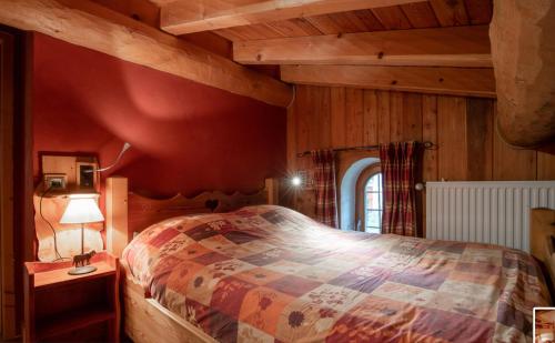 a bedroom with a bed and a red wall at Chalet Les Liouès in Sollières-Sardières