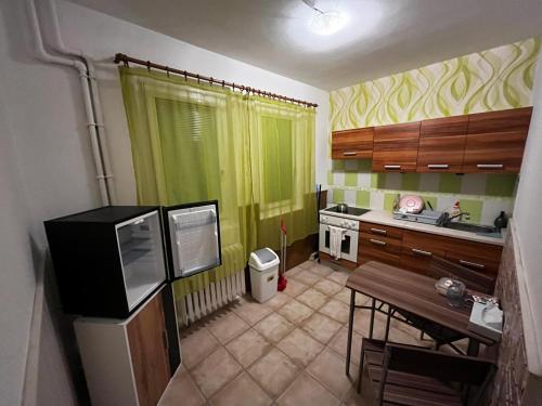 een kleine keuken met een tafel en een groen gordijn bij Apartmán u nádraží in Bílina