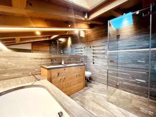 ein Badezimmer mit Badewanne und Dusche und Toilette in der Unterkunft 4 Bedroom Penthouse Apt in Flims Waldhaus in Flims