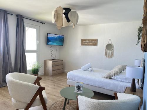 une chambre avec un lit, une table et des chaises dans l'établissement La Marina, à Calais