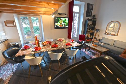 a living room with a table and chairs and a couch at DUPLEX 5 chambres Clim WIFI SAUNA Cannes in Cannes