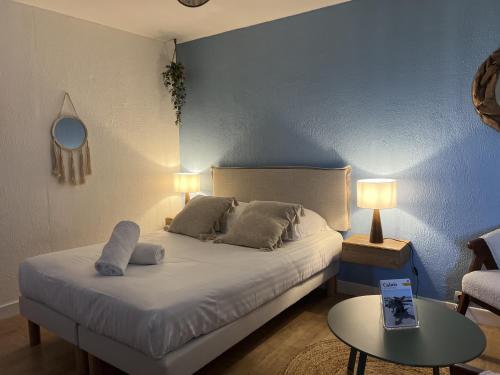 une chambre avec un lit avec deux oreillers et une table dans l'établissement La Marina, à Calais