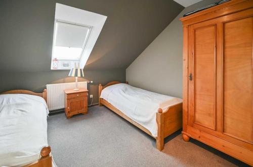 een slaapkamer op zolder met 2 bedden en een raam bij Jule - Sonnenhof 9 in Kellenhusen