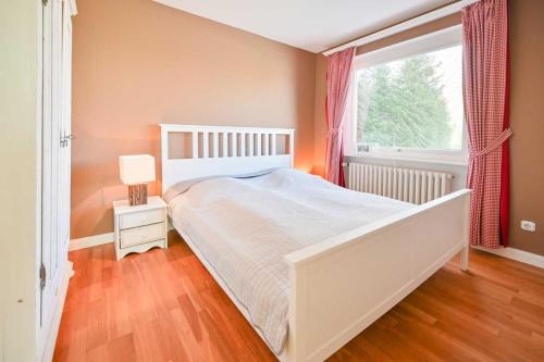 ein Schlafzimmer mit einem weißen Bett und einem Fenster in der Unterkunft Noah - Sonnenhof 7 in Kellenhusen