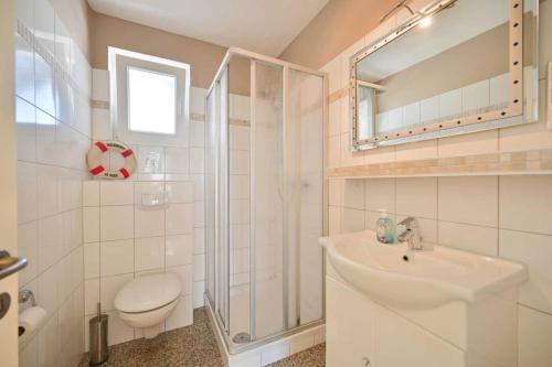 een badkamer met een wastafel, een douche en een toilet bij Noah - Sonnenhof 7 in Kellenhusen